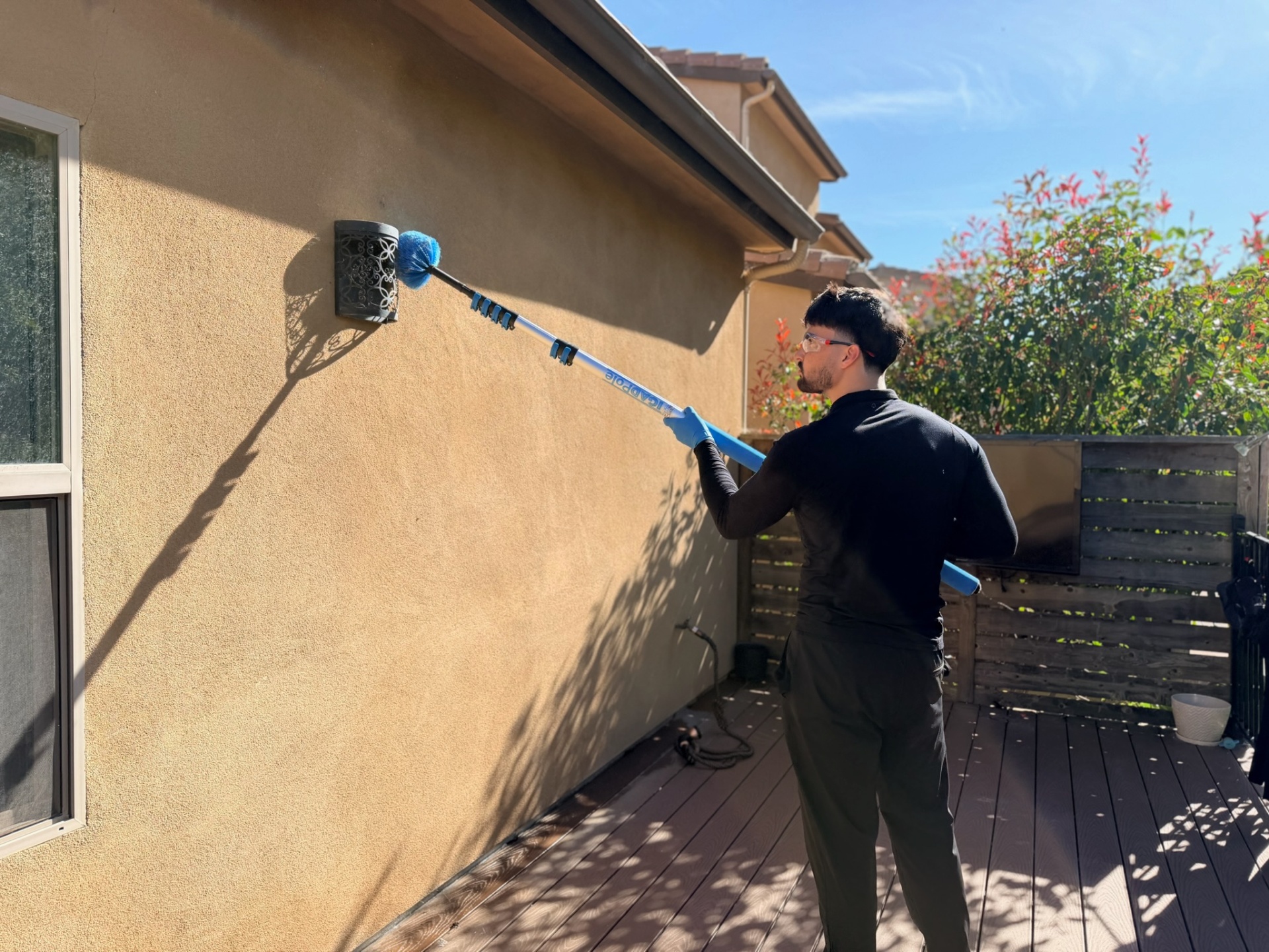 Eddie de-webbing a home exterior
